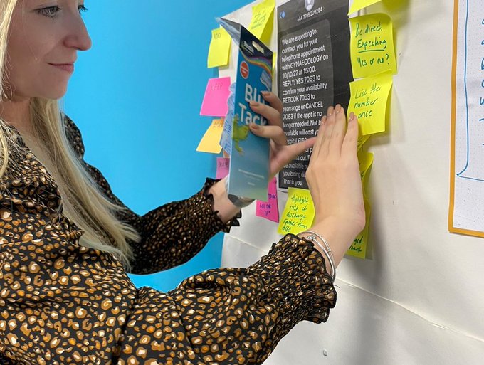 Amy with flip chart, post its, blutack, example sms content, suggested improvements